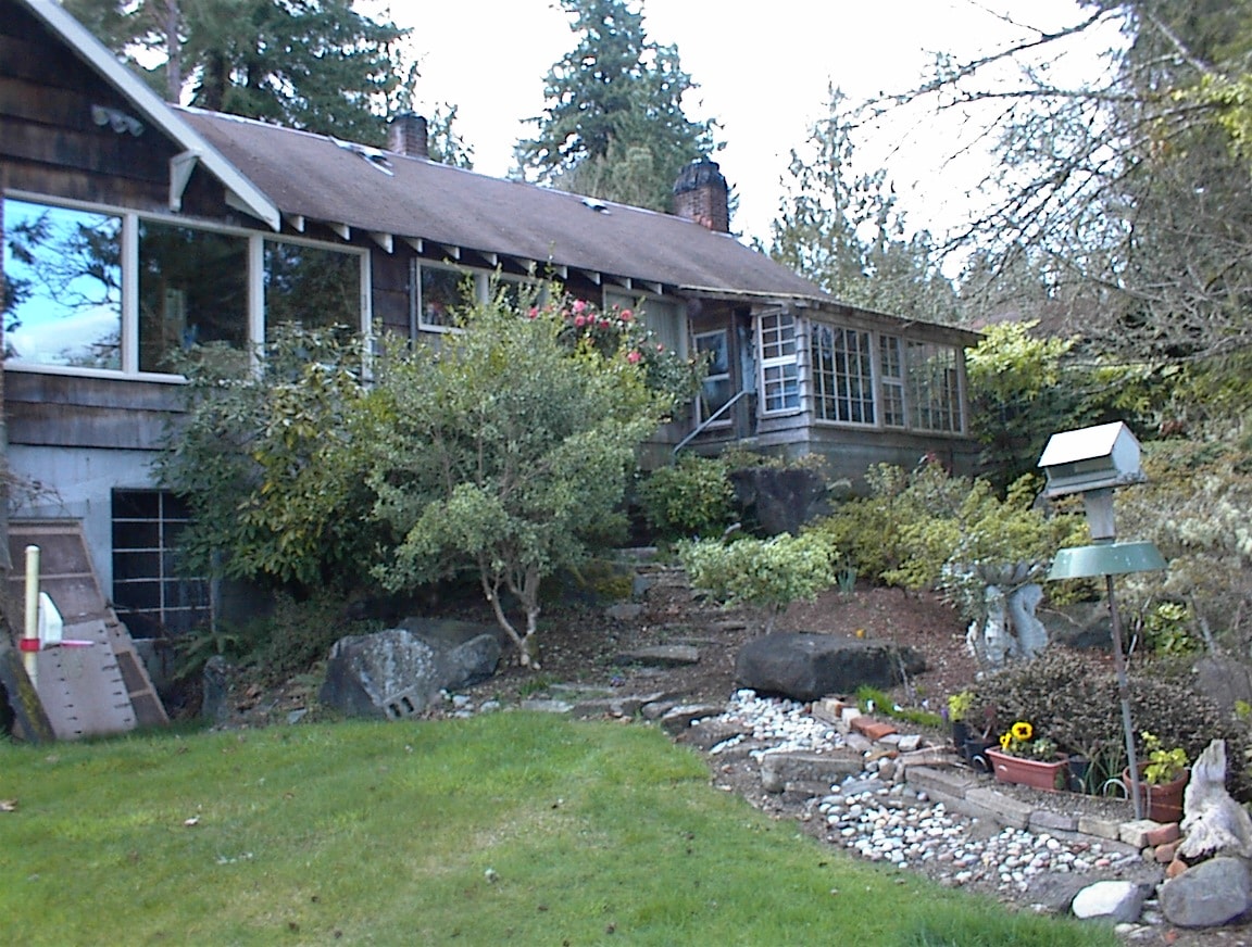Front of house with garden, rhododendrons, rock steps and birdfeeder