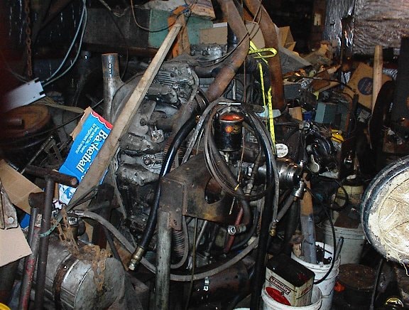 Cluttered workshop interior with vintage engine parts and tools